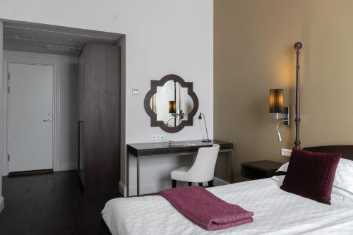 a bedroom with a bed and a desk and a mirror at Elite Plaza Hotel Malmö in Malmö