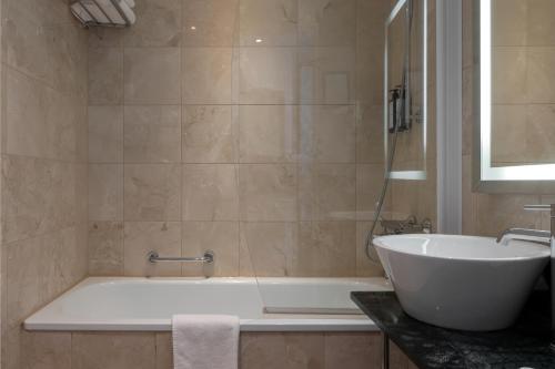 a bathroom with a white tub and a sink at Elite Plaza Hotel Malmö in Malmö