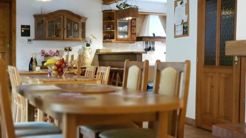 a kitchen with wooden tables and chairs in a room at Elitní wellness penzion U Dvou jedlí v srdci Českého ráje in Turnov