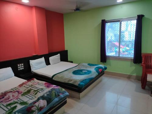 two beds in a room with red and green walls at Ditto Room Hotel Kartik, Deoghar in Deoghar