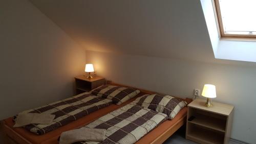 2 łóżka pojedyncze w pokoju z 2 lampami w obiekcie Elitní wellness penzion U Dvou jedlí v srdci Českého ráje w mieście Turnov