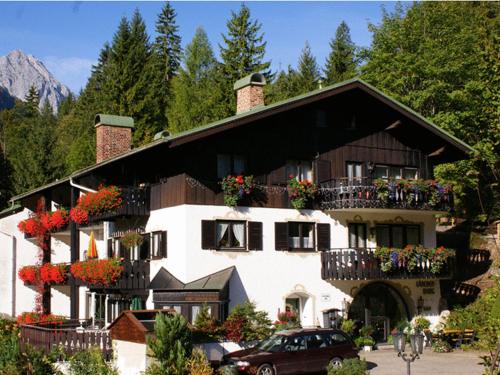 a large white building with flowers on the balconies at Gästehaus Lärchenhang in Mittenwald
