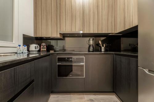 a kitchen with wooden cabinets and an oven at Madrid 1915 Private Suites in Madrid