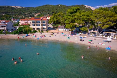 eine Gruppe von Menschen im Wasser an einem Strand in der Unterkunft Apartments Villa Alba in Banjol