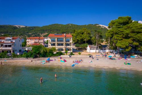 a group of people on a beach in the water at Apartments Villa Alba in Banjol