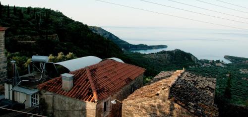 a view of a mountain with houses and the ocean at Pyrgos Fassea Kardamyli Towerhouse in Kardamili