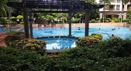 a large swimming pool with people in the water at Century Mahkota Apartments in Melaka
