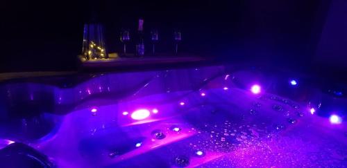 a purple bathtub with lights in a dark room at Srub Karpatský in Vlčeves