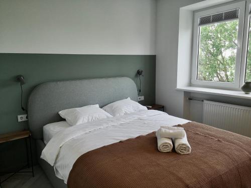 ein Schlafzimmer mit einem Bett mit einem Paar Schuhe darauf in der Unterkunft Hill Top apartment in central Kedainiai in Kėdainiai