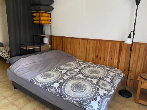 une chambre avec un lit avec une couverture noire et blanche dans l'établissement studio climatisé avec parking, à La Londe-les-Maures