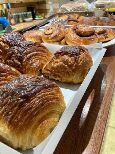 een stapel croissants en ander gebak op een tafel bij OA Surf Club in Bude