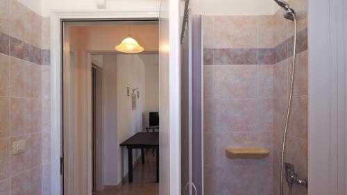 um chuveiro com uma porta de vidro na casa de banho em Appartamenti Torre Suda by Salento Affitti em Torre Suda