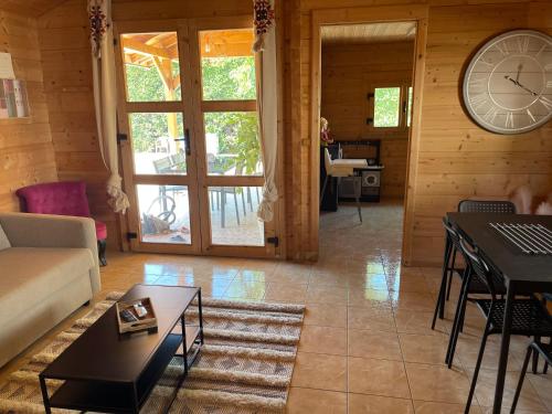 a living room with a large clock on the wall at Magnifique chalet aux portes de la Drôme in Saint-Rambert-dʼAlbon