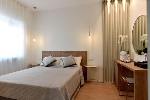 a bedroom with a bed and a desk and a mirror at Dimora Al Castello in Matera