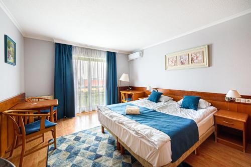 pokój hotelowy z dużym łóżkiem i oknem w obiekcie Holiday Club Apartman Hotel w Hévízie