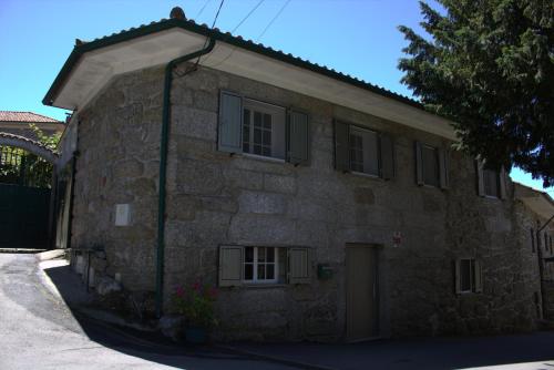 a stone building with a door and windows on it at Casa do Posto in Carvalheira