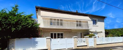 a house with a white fence in front of it at Le Petit Paradis in Brive-la-Gaillarde