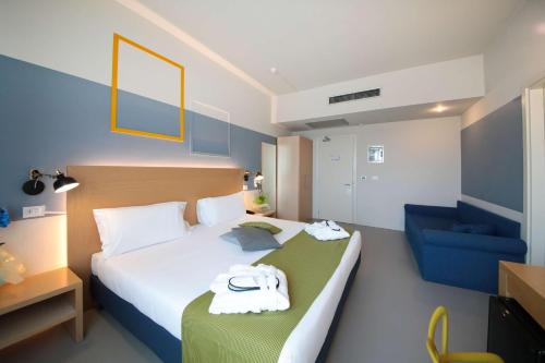 a hotel room with a bed and a blue chair at Best Western Hotel Cristallo Mantova in Virgilio