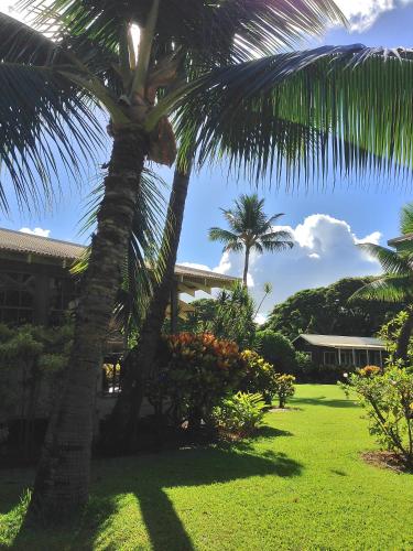 a palm tree in a yard next to a building at Waimea Plantation Cottages, a Coast Resort in Waimea
