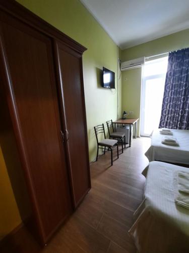 a hotel room with two beds and a table and chairs at Delta Hotel in Ureki