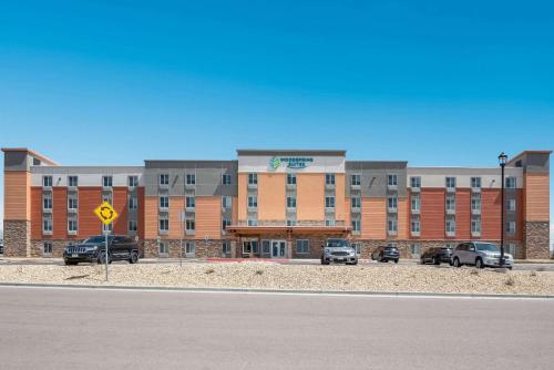 a large building with cars parked in a parking lot at WoodSpring Suites Colorado Springs North - Air Force Academy in Colorado Springs