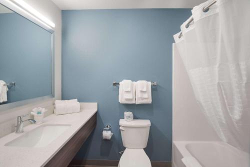 a bathroom with a white toilet and a sink at WoodSpring Suites Colorado Springs North - Air Force Academy in Colorado Springs