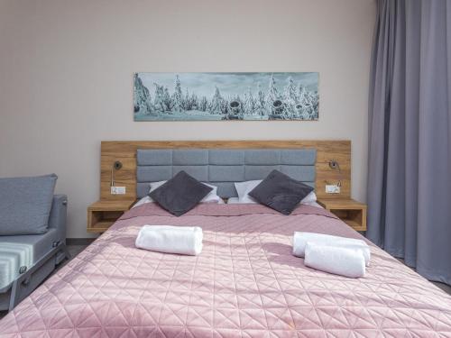 a bedroom with a pink bed with two pillows at Aparthotel Apartamenty Czarna Góra 138 in Sienna