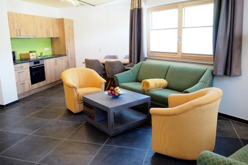 salon z kanapami, krzesłami i stołem w obiekcie Apartment Goaßa - Familie Zehner w mieście Göriach
