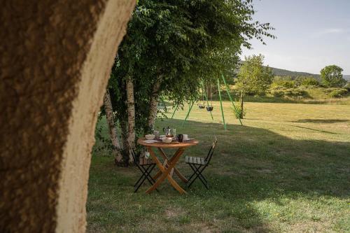 einen Tisch und Stühle im Gras unter einem Baum in der Unterkunft Val de Llous I 40 in Sainte-Léocadie
