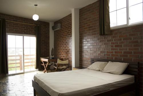 a bedroom with a brick wall and a bed at Muyuyo Lodge in Ayangue