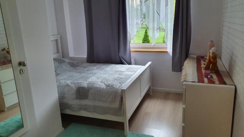 niewielka sypialnia z łóżkiem i oknem w obiekcie Spokojna APT w mieście Katowice