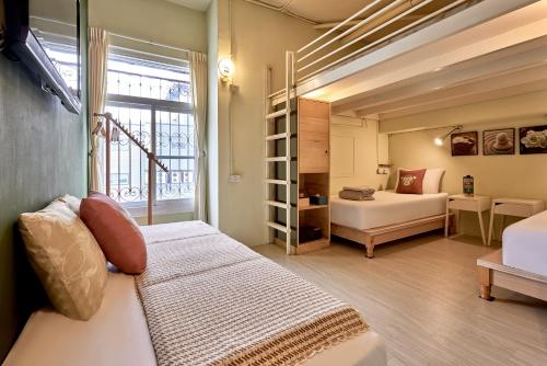 嘉義市的住宿－安蘭居旅店 An Lan Jie Hotel，一间卧室配有一张床,另一间卧室配有窗户