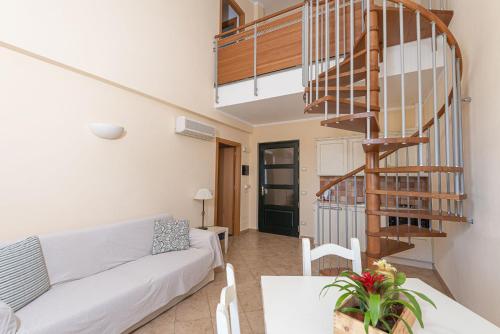 a living room with a couch and a spiral staircase at Salvapiano Holiday Ranch in Riotorto
