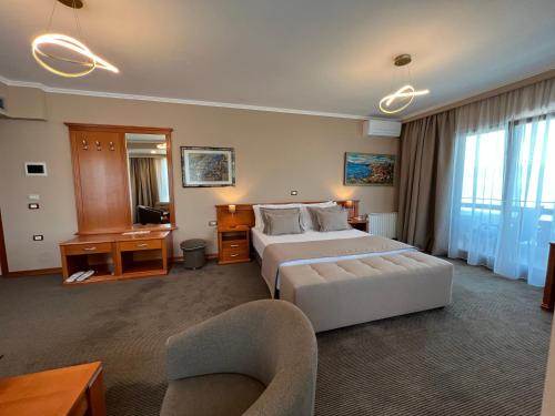 a large hotel room with a bed and a chair at Hotel Millennium in Pogradec