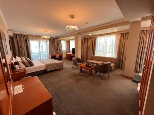 a hotel room with a bed and a couch at Hotel Millennium in Pogradec