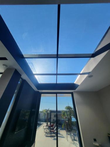 a large glass ceiling in a building with chairs at La Mirage Villa in Rrushkull