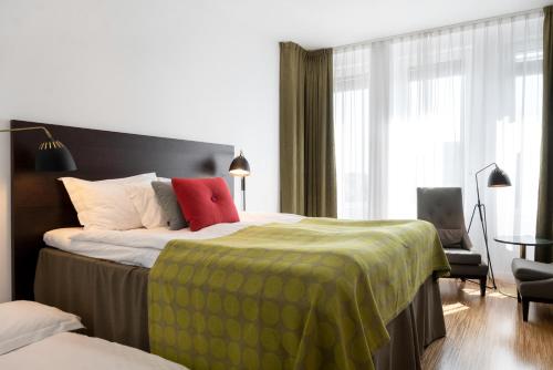 a hotel room with a bed with a green blanket at Elite Hotel Ideon, Lund in Lund