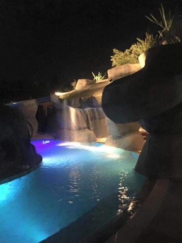 a swimming pool with a waterfall and blue lights at Happy Lagoon Bungalow in Khao Lak