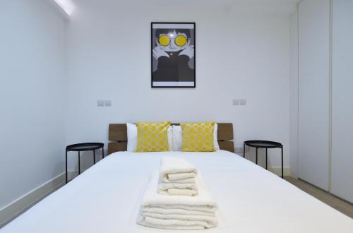 a bedroom with a white bed with towels on it at Soho 22 Serviced Apartments by Concept Apartments in London