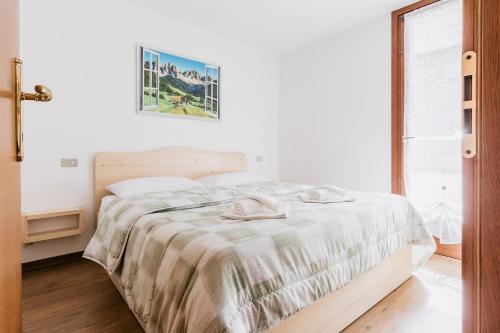 Un dormitorio blanco con una cama con una cruz. en [Campiglio-Apartment] Free Parking & Self Check-in, en Madonna di Campiglio