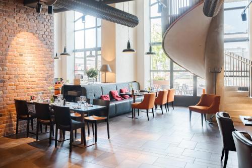 a restaurant with tables and chairs in a room with windows at Solo Sokos Hotel Torni Tampere in Tampere
