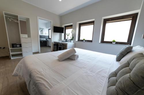 a bedroom with a large white bed with two windows at B&B Ruggero Settimo - Room & Suite in Palermo