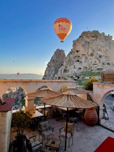 a hot air balloon flying over a mountain at Duven Hotel Cappadocia in Uchisar