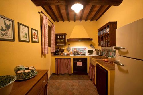 a kitchen with a refrigerator and a counter top at Le Mascie in Sovicille