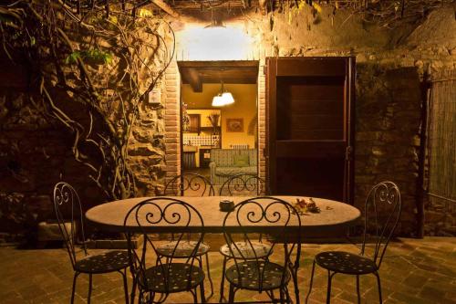 a dining table and chairs in a room at Le Mascie in Sovicille