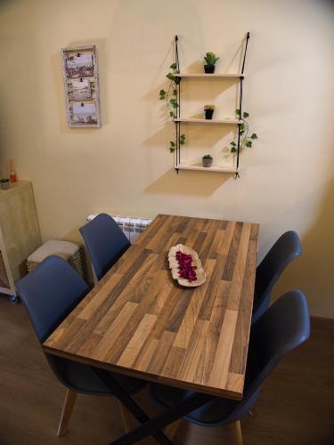 a wooden table with blue chairs and a cake on it at Grace, apartamento con terraza y vistas in Talarn