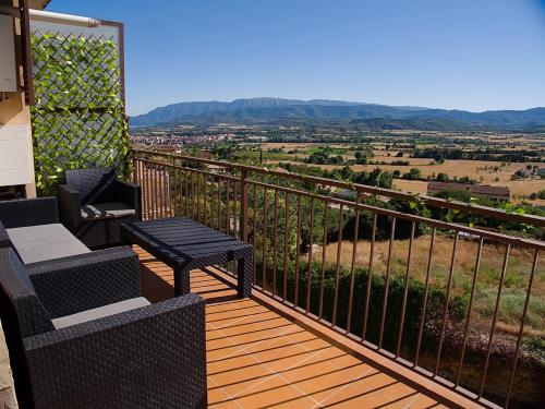 a balcony with two chairs and a table with a view at Grace, apartamento con terraza y vistas in Talarn