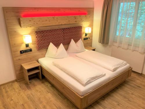 a bedroom with a bed with white sheets and a red ceiling at Hotel Garni Siegmundshof - inclusive Joker Card im Sommer in Saalbach Hinterglemm