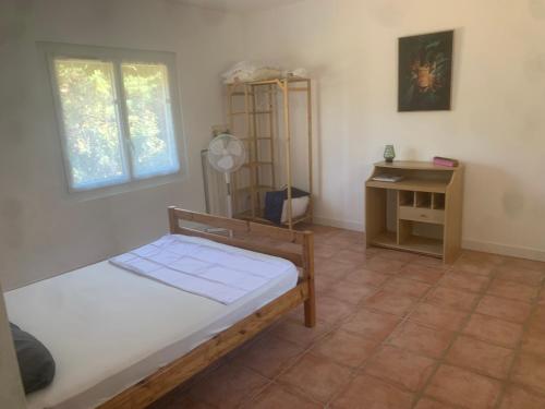 a bedroom with a bed and a desk and window at Adorable guest house en pleine nature,la nautique in Narbonne