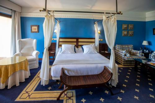 a bedroom with a bed and a couch and a chair at Hotel Soho Boutique Vistahermosa in El Puerto de Santa María